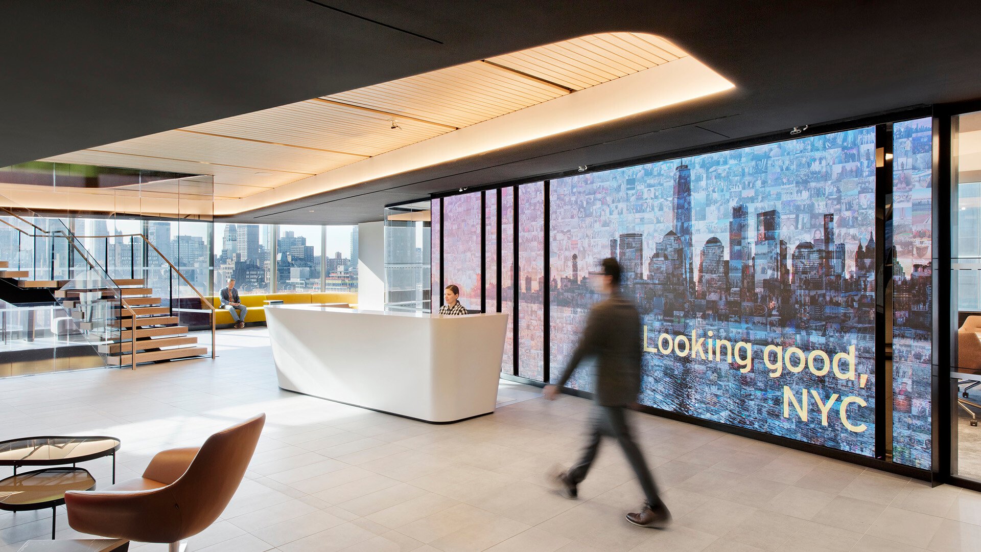 Modern corporate office lobby overlooking New York City skyline at dusk